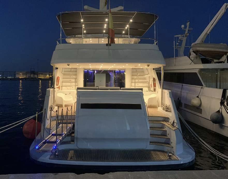 Rear deck and illuminated outdoor lounge aboard Explorer 92 yacht at night