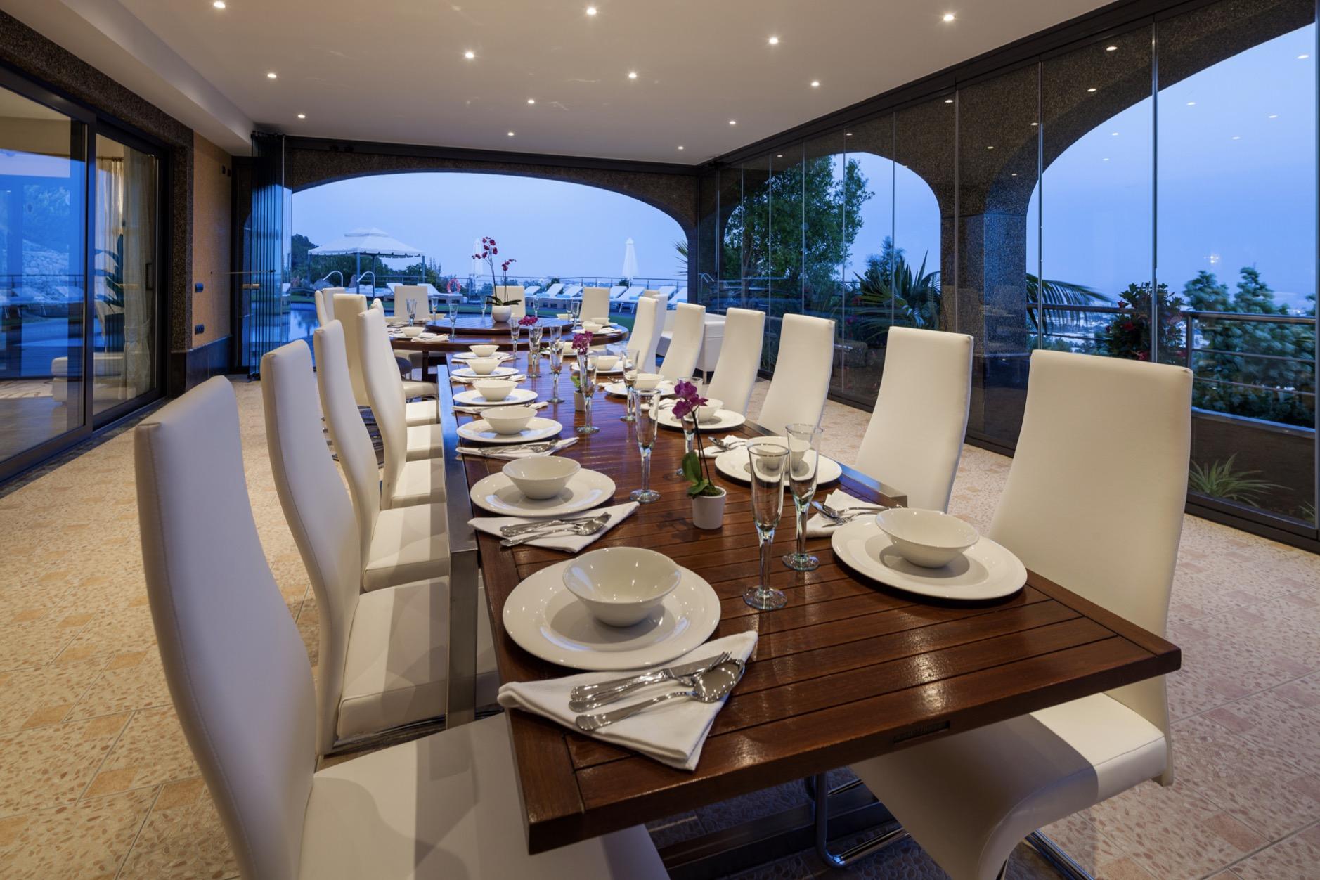 Elegant outdoor dining terrace with panoramic Ibiza sunset views at Villa Tauranga