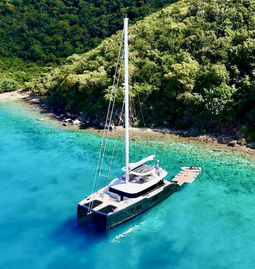 Sunreef 70+ luxury catamaran anchored near Ibiza coastline